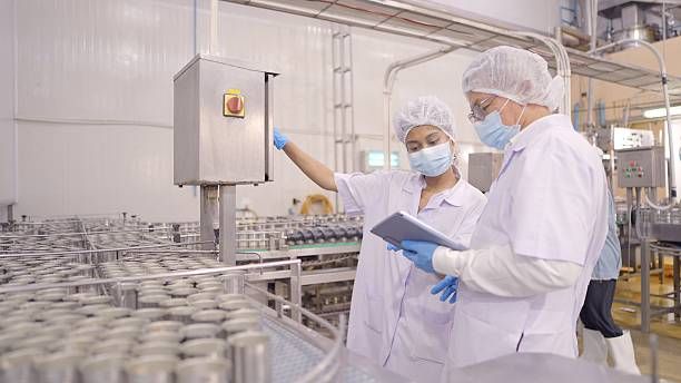 生産ラインでタブレットを確認する製造スタッフ