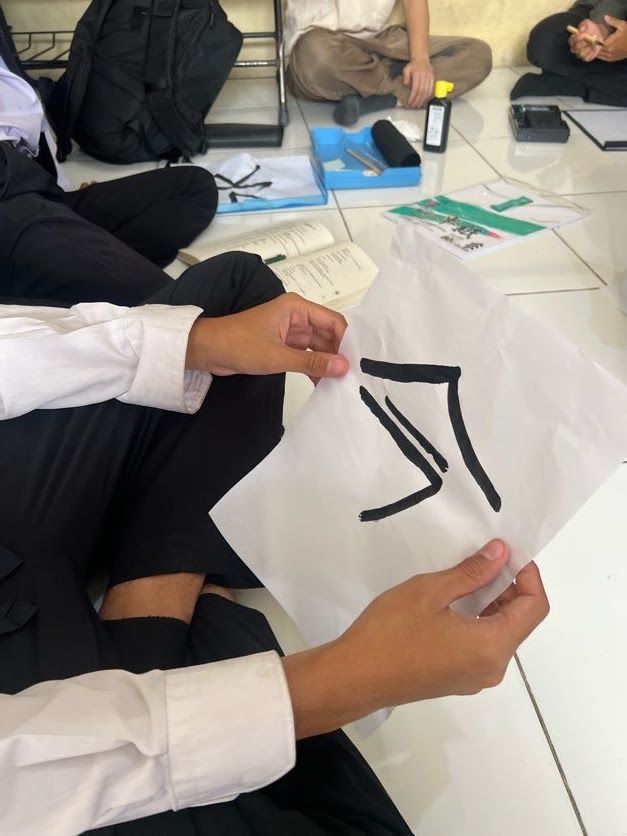 筆で書いた一画を掲げる手