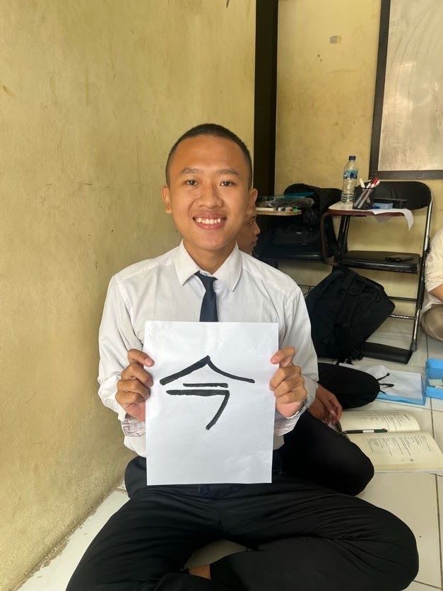 「今」と書いた半紙を持つ受講生